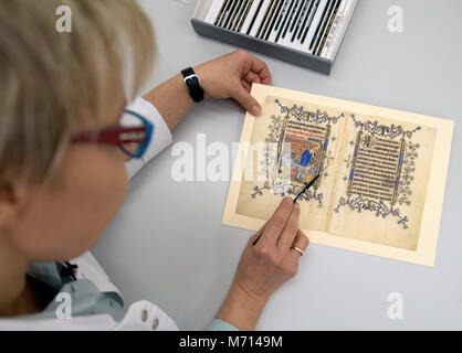 21 février 2018, Allemagne, Berlin : Restaurateur Katarzyna Schirmacher travaille sur une page originale de Marie de Gueldre' livre de prières. Pour la première fois, les pièces de plus de 600 ans, livre de prière la cité médiévale Reine consort d'Écosse Marie de Gueldre sont d'être publiquement disponible bientôt. Photo : Ralf Hirschberger/dpa-Zentralbild/dpa Banque D'Images