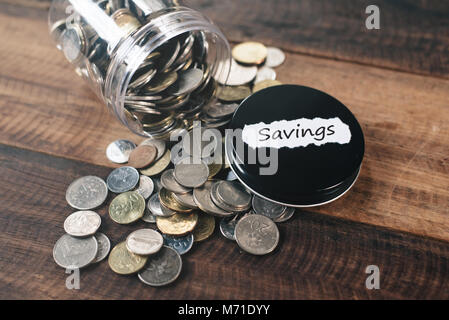 Pile de pièces de monnaie dans un pot avec l'étiquette d'épargne épargne financière écrite. concept Banque D'Images