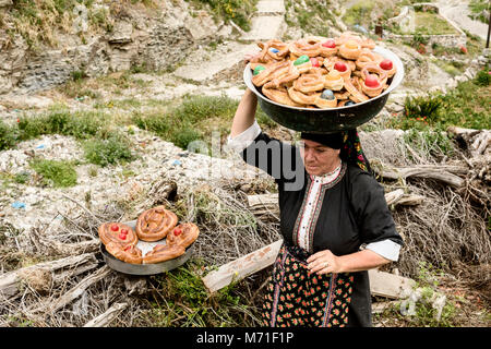 La Grèce, Îles de la mer Égée, l'île de Karpathos, Olympos, une femme ramasse tous les petits pains décorés avec un oeuf de Pâques colorés Banque D'Images