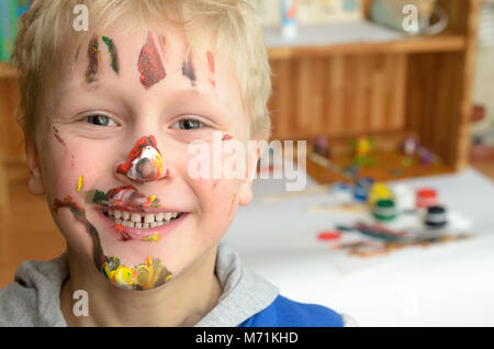 Le visage de l'enfant, de traces de peinture, de rires drôle et joyeusement Banque D'Images