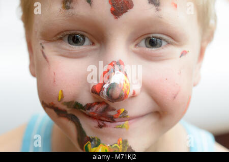 Le visage de l'enfant, de traces de peinture, de rires drôle et joyeusement Banque D'Images