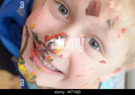 Le visage de l'enfant, de traces de peinture, de rires drôle et joyeusement Banque D'Images