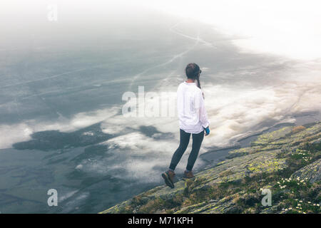 Une fille en plein air voyages dans le contexte d'un paysage de rochers et épique d'un lac dans le brouillard. Banque D'Images