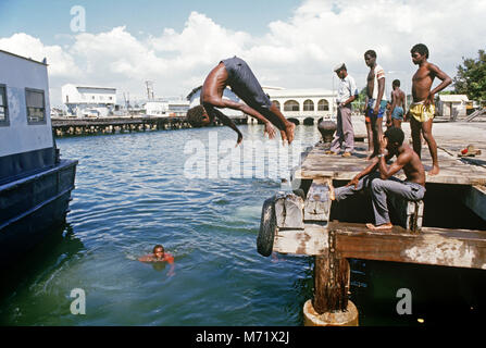 Enfants jamaïcains la natation et la plongée dans le port de Kingston, Jamaïque Banque D'Images