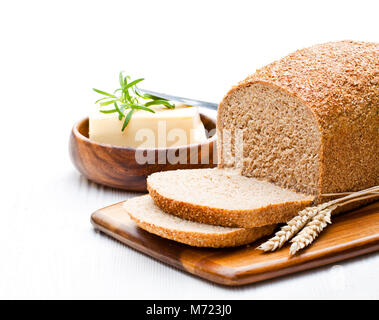 Slow-tranchés pain complet bio au four avec du beurre et de romarin et les épis de blé Banque D'Images