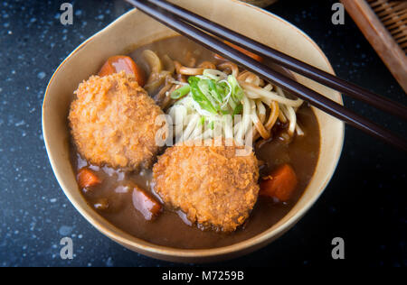 Curry japonais avec des nouilles Udon et côtelette de porc croustillant nappage sur croquettes style coupe bol. Banque D'Images