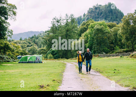 Senior couple sont bénéficiant d'une belle promenade à travers la forêt à la région des lacs. Banque D'Images