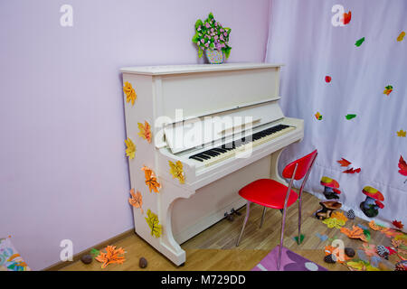 Chambre blanche avec colonnes et le piano sur un mur . Grand piano blanc sur un fond blanc. jouer de la musique . Banque D'Images