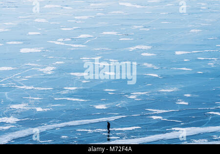 Le lac Baïkal gelé vue aérienne paysage avec un homme qui marche sur la glace. Belle texture paysage lac gelé Banque D'Images