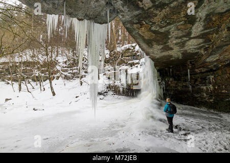 Walker debout dans Gibson's Cave en voyant une force de Summerhill, Bowlees, Upper Teesdale, comté de Durham, Royaume-Uni. Banque D'Images