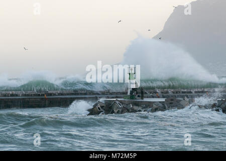 Les pêcheurs bravant les vagues énormes qui sont vus ici s'écraser contre la digue du port de Kalk Bay à Cape Town, Afrique du Sud. Banque D'Images