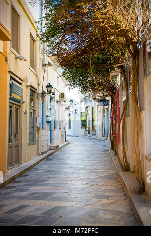 Rue Pierre étroites avec des arbres sur les murs menant au centre de l'île de Syros, Cyclades , Grèce Banque D'Images