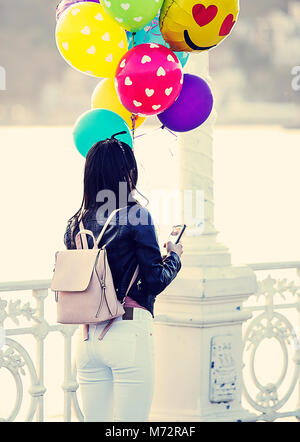 San Sebastian, Spain-March 07,2018 : Jeune fille aux ballons colorés promenades le long de la promenade de la Concha, San Sebastian Banque D'Images