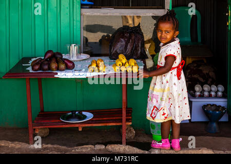 Une petite fille se l'extérieur d'une boutique vendant des fruits, Arba Minch, Gamo Gofa Zone, Ethiopie Banque D'Images