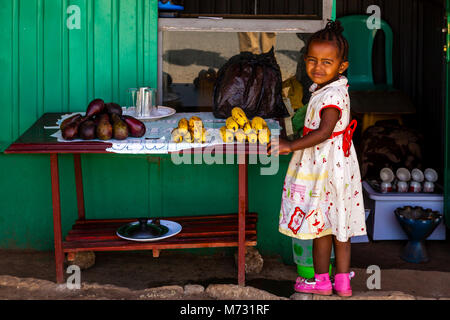 Une petite fille se l'extérieur d'une boutique vendant des fruits, Arba Minch, Gamo Gofa Zone, Ethiopie Banque D'Images