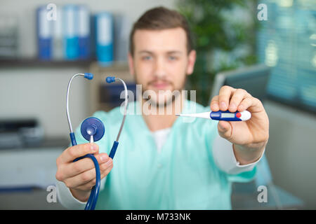 Male doctor holding stethoscope et thermomètre Banque D'Images