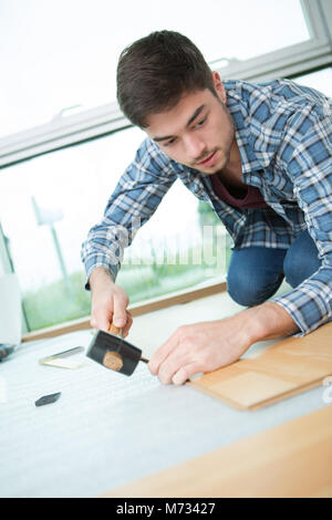 Jeune homme pose plancher en bois Banque D'Images