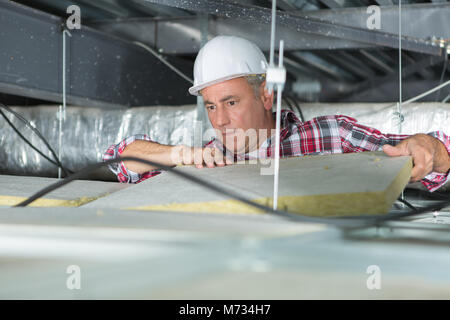 Travailleur de la construction maison Isolant thermique en laine minérale avec grenier Banque D'Images