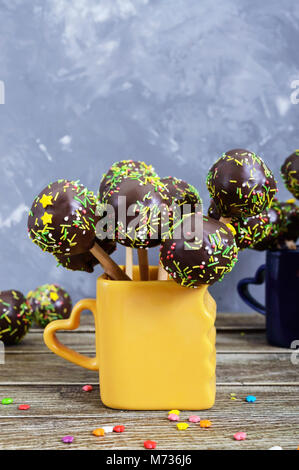 Maison de vacances cake pops, décoré avec du chocolat blanc et noir dans cups sur un fond de bois. Candy sur un bâton. Vue verticale Banque D'Images