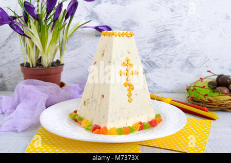 Caillé traditionnel gâteau de Pâques avec des fruits confits et des œufs en chocolat, fleurs de printemps crocus sur l'appartement de fond clair. Le fromage cottage Pâques dess Banque D'Images