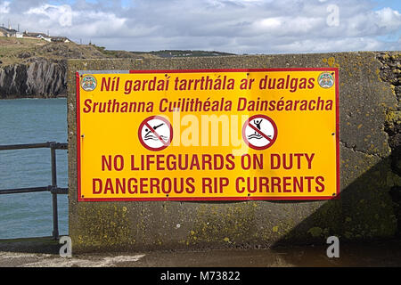 Marées Rip Danger sign en anglais et en gaélique. L'enseigne est à l'extrémité d'une jetée dans Rossbarbery, l'Irlande, où les courants aller vraiment ! ! Banque D'Images