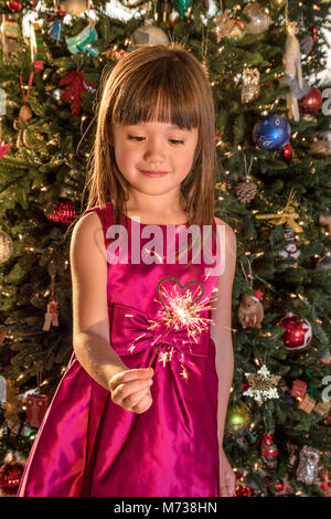 Petite fille de cinq ans holding a sparkler à Noël Banque D'Images