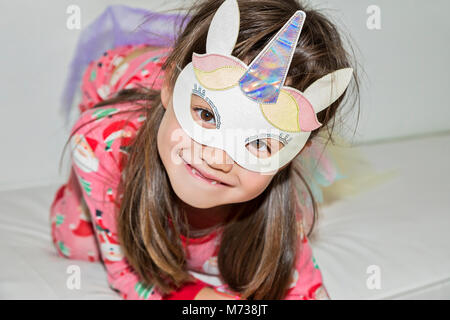 Une fillette de six ans portant un costume de licorne Banque D'Images