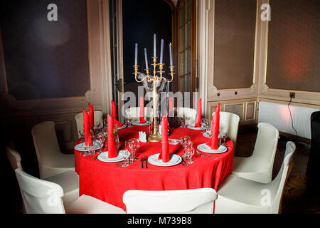 Servi table en rouge et blanc avec des chandeliers et des bougies bleu décoré avec web imitation en style gothique sur banquet service traiteur Banque D'Images