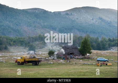 Image panoramique d'une petite cabane en bois avec la ferme et vieux camion et voiture à la montagne Monténégro Banque D'Images