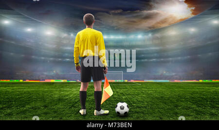 Ballon de soccer sur le terrain de stade avec lumière . Arbitre sur le terrain avant le match Banque D'Images