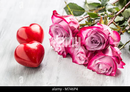Roses. Roses rose avec deux coeurs et cadeau rouge. Banque D'Images