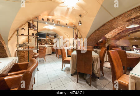 Moscou - Juillet 2014 : l'intérieur de la bière restaurant 'CAPITAL' situé dans une ancienne cave avec voûtes en briques. Salle avec tables et chaises en cuir Banque D'Images