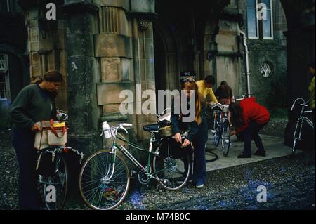 Un groupe de jeunes adultes qui voyagent en vélo ont cessé d'inspecter leurs vélos et effets personnels à l'avant d'un bâtiment en pierre, 1965. () Banque D'Images