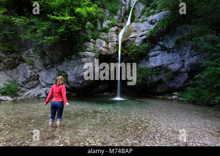 Femme debout pieds nus dans l'eau, cascade de s'éclabousser dans la piscine d'Emeraude Banque D'Images