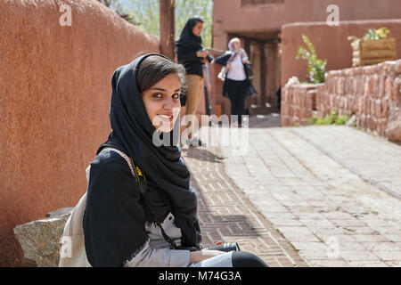 Abyaneh, Iran - le 26 avril 2017 : jeune femme iranienne en hijab se trouve dans village traditionnel de montagne et sourit. Banque D'Images