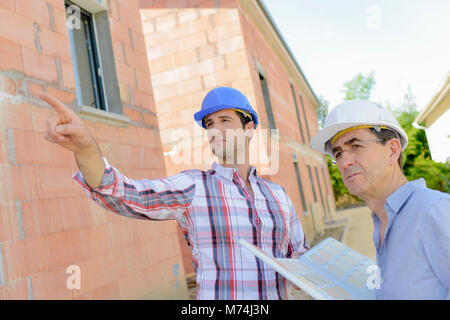 Foreman pointing at maison inachevée Banque D'Images