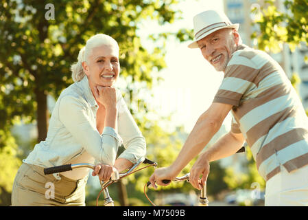 Couple âgé positive faire du vélo ensemble Banque D'Images