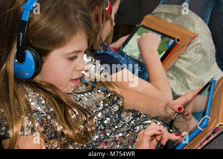 Portrait horizontal de deux filles jouer à des jeux sur ordinateur. Banque D'Images