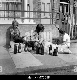 Les jeunes garçons la collecte de bouteilles en verre pour recueillir le dépôt et de faire un peu d'argent de poche dans le sud de Londres 1970 Banque D'Images