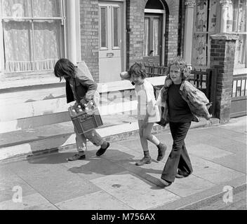 Les jeunes garçons la collecte de bouteilles en verre pour recueillir le dépôt et de faire un peu d'argent de poche dans le sud de Londres 1970 Banque D'Images