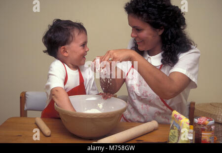 La mère et l'enfant en faisant des tartelettes à la confiture ensemble Banque D'Images