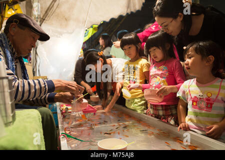 Tokyo, Japon - 17 mai 2019 : l'enfant japonais filles jouent au jeu des poissons rouges japonais écopant Summer Festival à Tokyo, Japon Banque D'Images