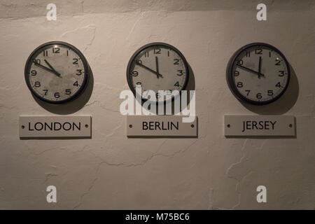 Trois horloges sur le mur représentant des temps à Londres,Berlin & Jersey War Tunnels sur l'affichage à l',Jersey,Channel Islands Banque D'Images