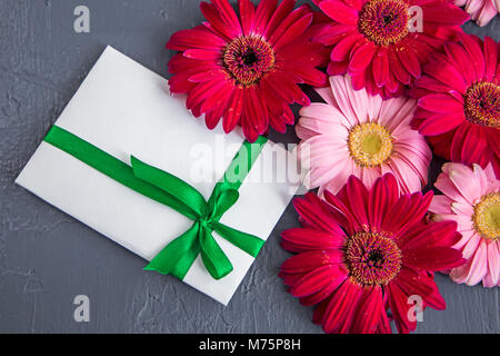 Un bouquet de gerbera rouge près de l'enveloppe. Vue de dessus Banque D'Images