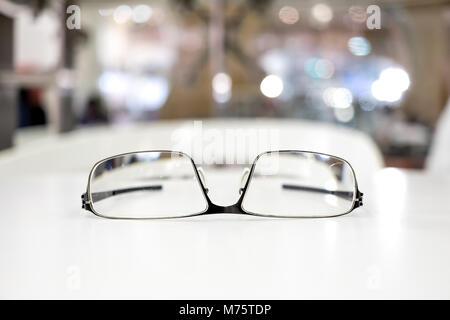 Les lunettes sur le tableau blanc avec fond bibliothèque décentreriez Banque D'Images