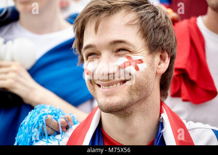 Fan de football britannique souriant gaiement au match, portrait Banque D'Images