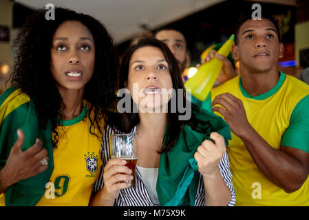Les supporters de football brésilien regarder match en bar Banque D'Images