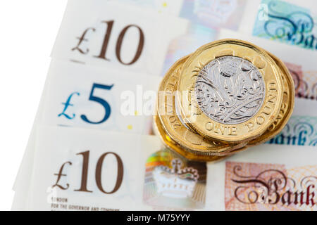 La pile d'un recto verso 12 pièces livre sterling argent livres sur polymère nouveau £10 et £5 notes GBP close-up sur un fond blanc. Angleterre Royaume-uni Grande-Bretagne Banque D'Images