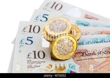 La pile de 12 £ recto verso des pièces d'une livre sterling d'argent comptant sur les nouveaux livres en plastique polymère £10 et £5 GBP notes sur découpe blanc. Angleterre Royaume-uni Grande-Bretagne Banque D'Images