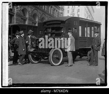 Cette photographie montre le maître des postes Will Hayes et d'autres fonctionnaires du bureau de poste américain inspectant des camions blindés nouvellement conçus, destinés à protéger le courrier pendant le transport. L'image date du 1er décembre 1921. Banque D'Images